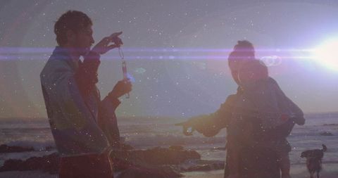 Couple Blowing Bubbles at Rocky Ocean Sunset