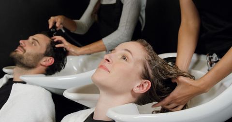 Couple relaxing with professional hair wash in modern salon