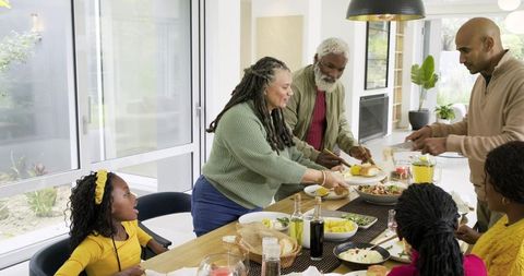 Multigenerational African American Family Sharing Homemade Meal Around Sunlit Dining Table
