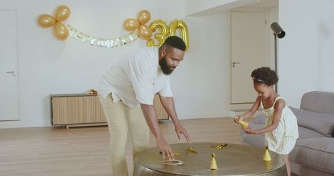 Father and daughter decorating for surprise 30th birthday celebration