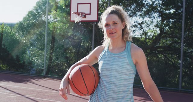 Woman Holding Basketball on Outdoor Court at Sunset - Download Free Stock Images Pikwizard.com