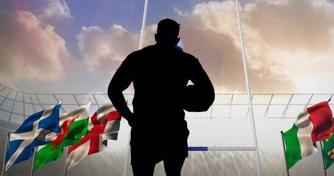 Silhouette of rugby player in stadium with flags