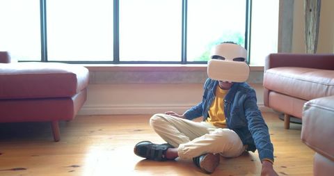 African American Boy Playing with VR Headset on Living Room Floor Between Leather Sofas