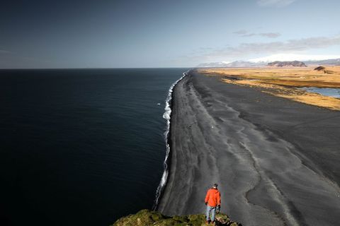 Solitary Hiker Overlooking Vik's Dramatic Black Sand Beach