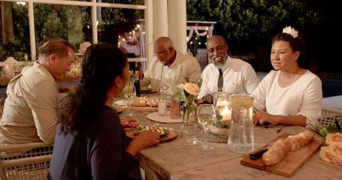 Diverse seniors celebrating at garden wedding table