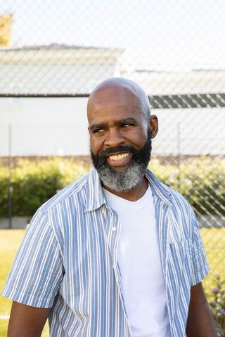 Senior african american man smiling outdoors near fence