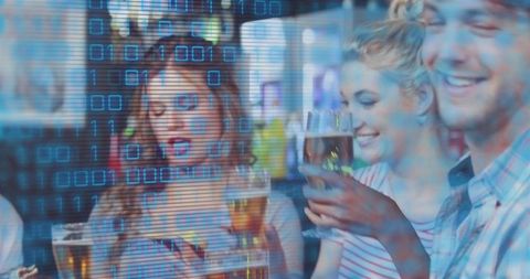 Young friends clinking beer glasses laughing in bar with urban digital binary overlay