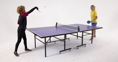 Diverse female athletes competing in table tennis match