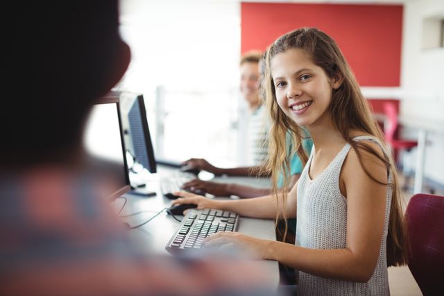 Portrait of student using computer in classroom at school