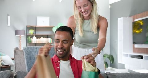 Cheerful Couple Celebrating Special Moment with Gifts in Decorated Living Room