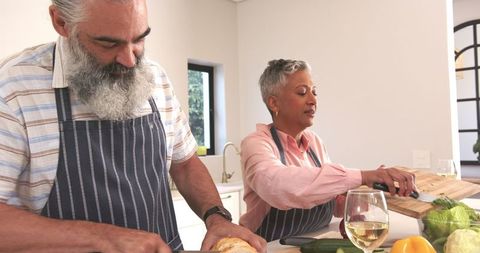 Senior Couple Enjoys Preparing Fresh Meal in Sunlit Kitchen