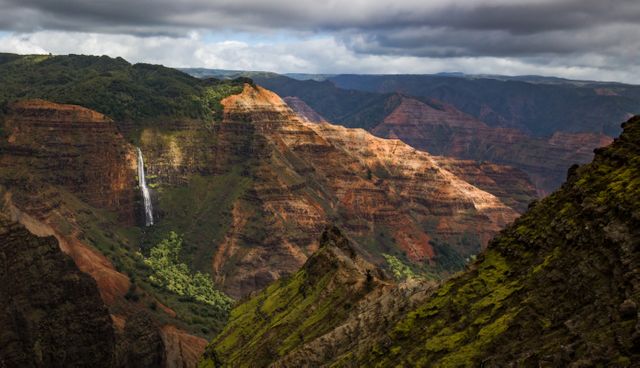 Waimea Canyon with its vivid colors and lush vegetation on vertical cliffs provides a breathtaking view that enhances any nature or travel-themed project. This picturesque scene is ideal for travel brochures, adventure blogs, wallpapers, or outdoor magazines highlighting scenic destinations.