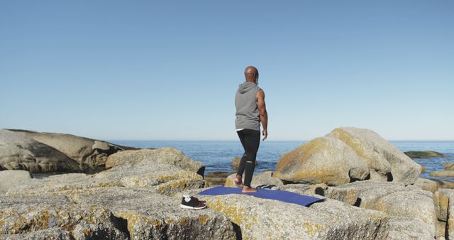 Man Practicing Yoga on Rocky Shore by Ocean - Download Free Stock Images Pikwizard.com