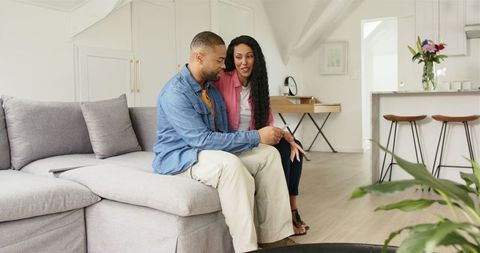 Couple Looking at Pregnancy Scan in Beautiful Living Room