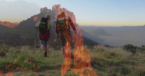 Couple Hiking Scenic Mountain at Sunrise with Fiery Overlay
