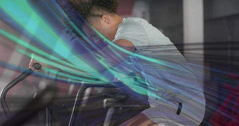 Man Exercising on Stationary Bike with Vibrant Light Streaks
