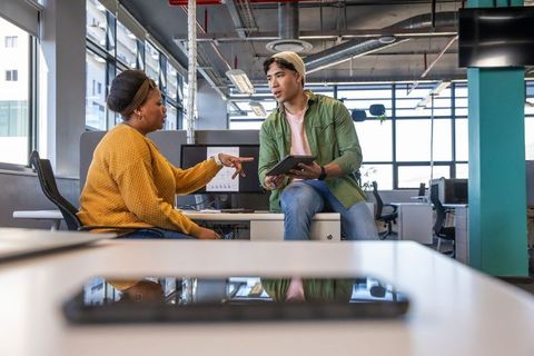Diverse coworkers collaborating and discussing strategy in modern bright office