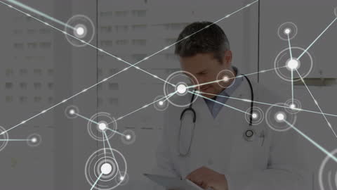 Doctor Using Digital Tablet in Hospital with Network Interface