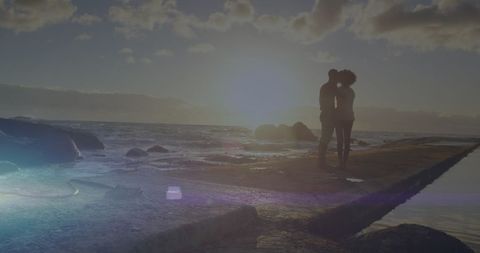Romantic couple embracing at tranquil beach sunset