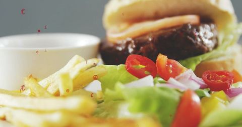 Gourmet beef burger with crispy fries and fresh salad close-up with dipping sauce