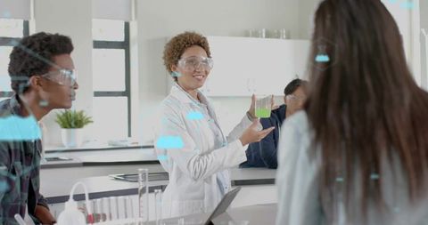 Female scientist demonstrating green chemical experiment to students in classroom laboratory