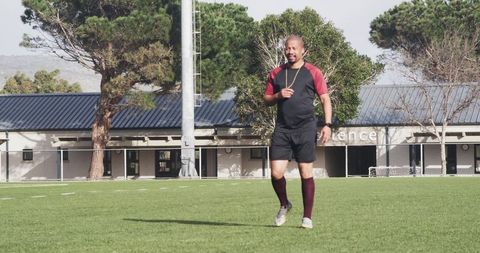 Soccer coach observing strategy session on field