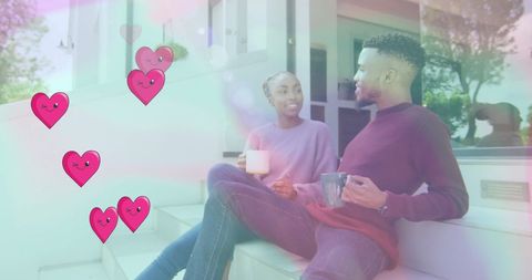 Happy Couple Enjoying Tea at Home with Digital Heart Graphics