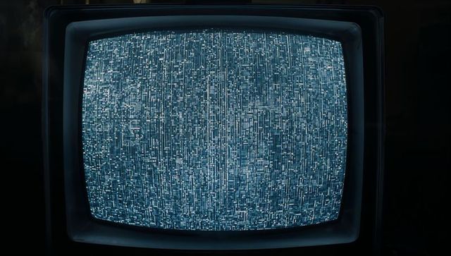 Vintage CRT Television Showing Blue Static Screen in Dim Light