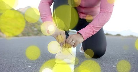 Runner Tying Shoes on Sunlit Mountain Road Ready for Adventure