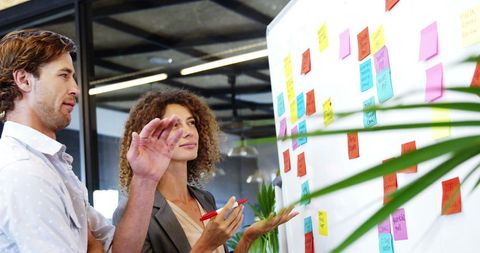 Business Colleagues Discussing Ideas with Sticky Notes in Modern Office