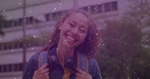 Smiling student with headphones in urban technological network