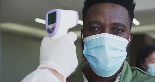 Man Undergoing Temperature Check Screening in a Medical Setting - Download Free Stock Images Pikwizard.com