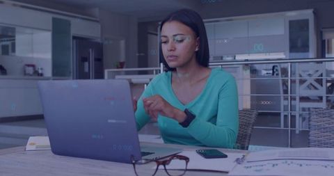 Focused Woman Organizing Documents on Laptop in Home Office