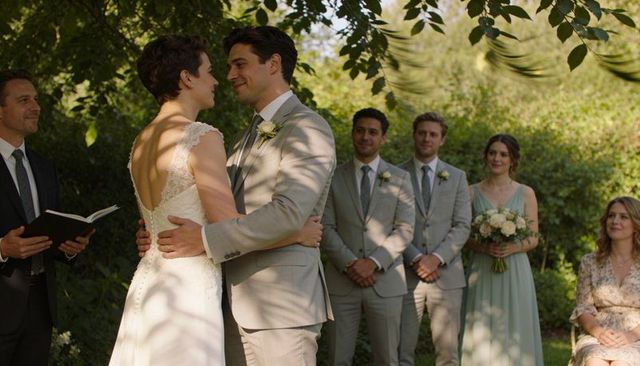 Bride and groom embracing under tree canopy during intimate garden wedding ceremony