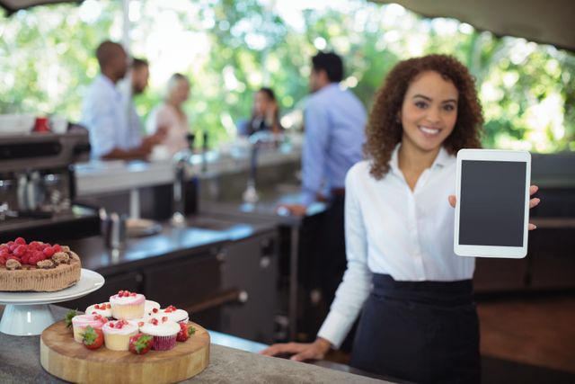 Waitress holding digital tablet at outdoor café, showcasing modern technology in customer service. Ideal for illustrating themes of hospitality, technology integration in restaurants, and professional service. Useful for marketing materials, advertisements for cafés, and articles on modern dining experiences.