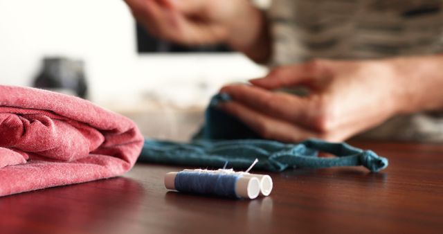 Hands Mending Clothes with Thread on Wooden Table - Download Free Stock Images Pikwizard.com