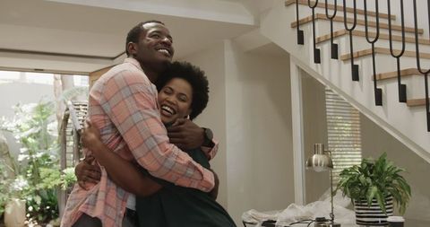Joyful Friends Embracing Together at Home in Living Room