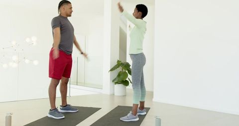 Diverse Workout Partners Stretching in Modern Home Gym