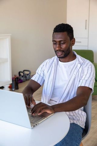 Focused Man Working on Laptop in Home Office