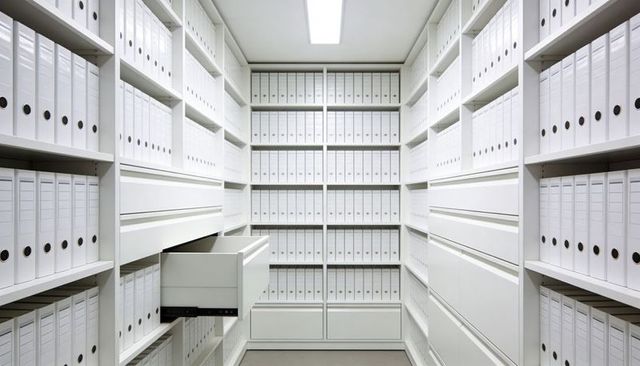 Minimalist archive storage storing white ring binders on modular shelves with open drawer