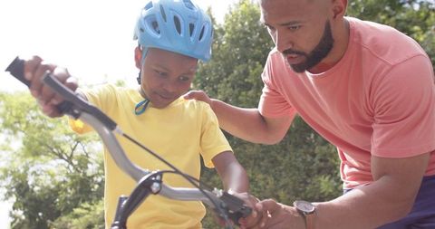Father Teaching Son to Ride Bicycle on Sunny Day in Garden - Download Free Stock Images Pikwizard.com