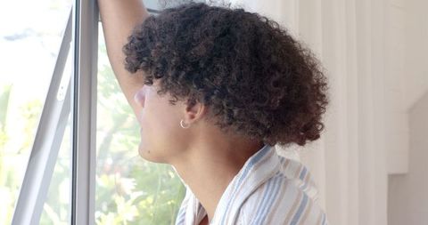 Man Relaxing at Window with Natural Light and Greenery