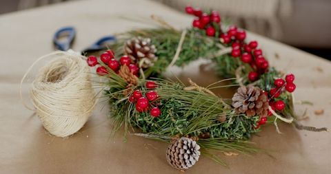 Rustic Holiday Wreath with Pine Cones and Berries on Brown Table