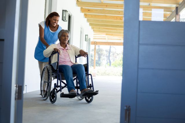 Female doctor pushing happy senior patient in wheelchair - Download Free Stock Photos Pikwizard.com