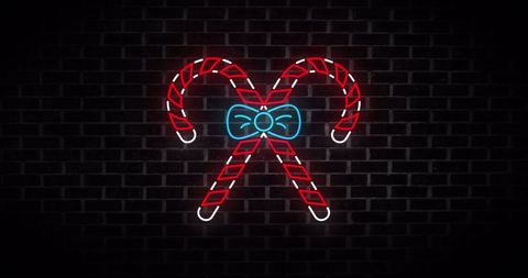 Neon candy canes with bow on dark brick wall