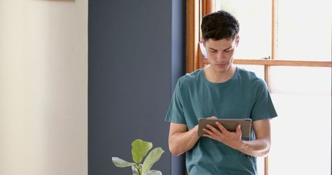 Young Man Engaged with Tablet in Bright Modern Living Room