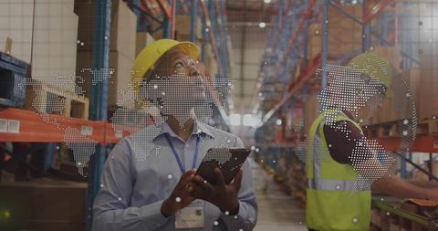 Warehouse manager inspecting inventory with tablet and AR overlay wearing yellow hard hat