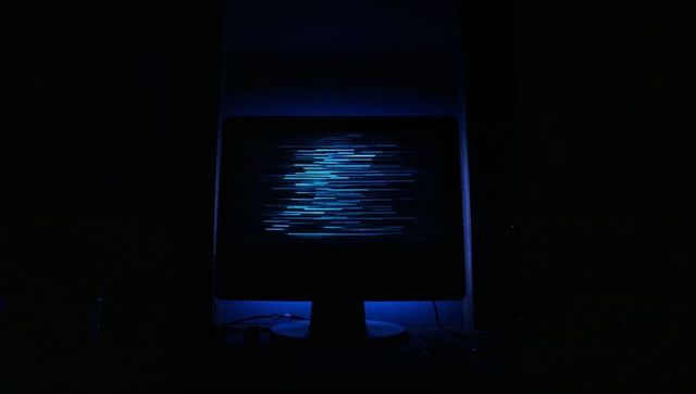 Futuristic Monitor Emitting Blue Light Streaks in Dark Room