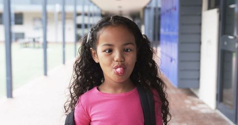 Cheerful Schoolgirl with Backpack Having Fun in School Corridor - Download Free Stock Images Pikwizard.com