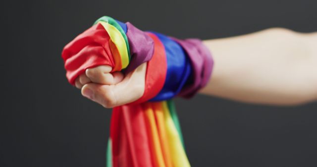 Image of hand of caucasian man with rainbow ribbon. Gender, lgbt, queer, gay pride and equality concept.